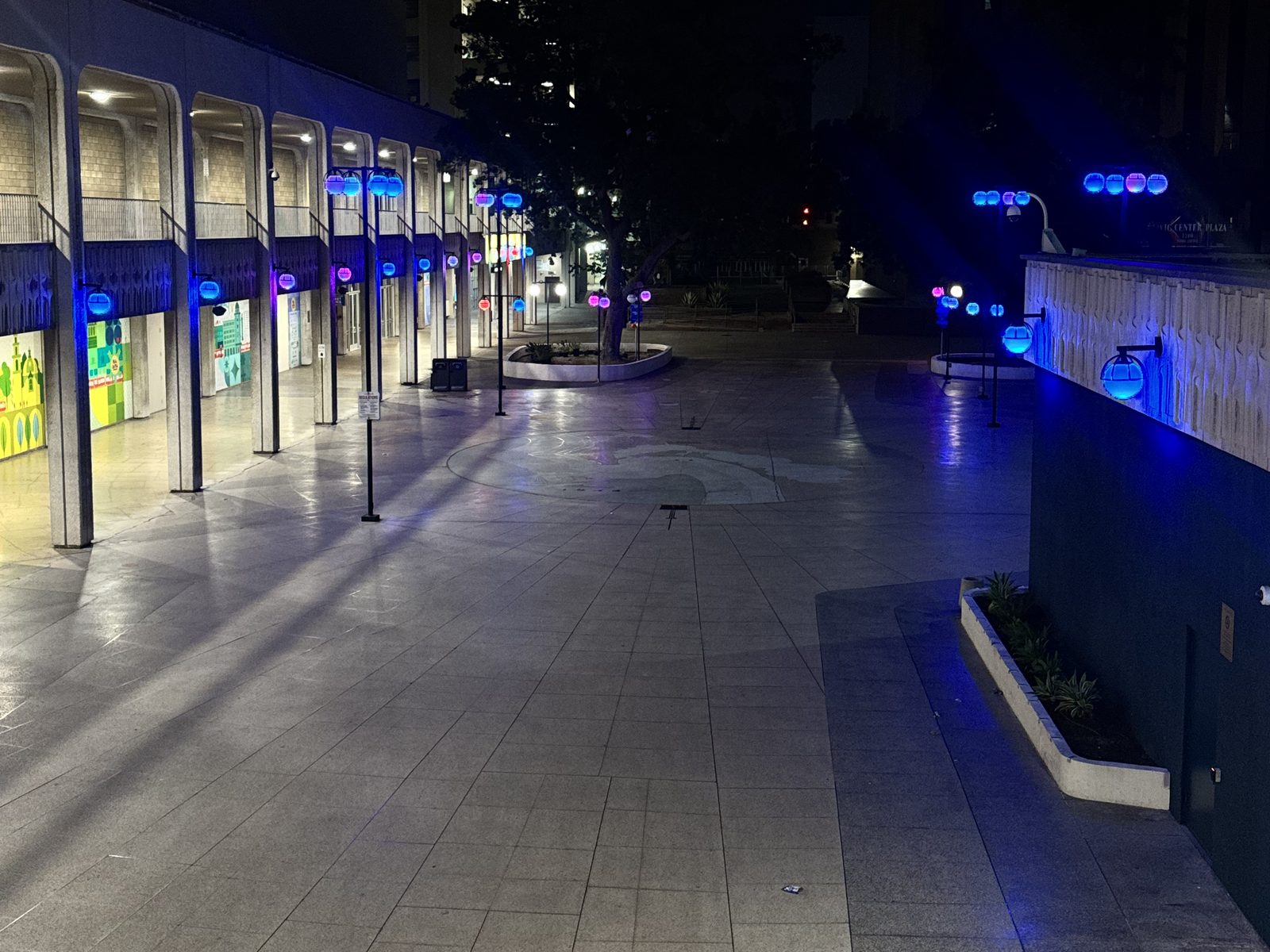 Civic Plaza walkways and arcade lit blue and violet at night